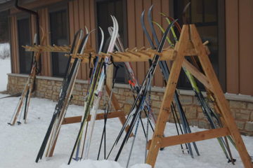 Several pairs of cross-country skis standing on an upright rack