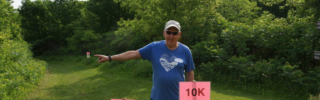 A volunteer points participants in the right direction during a trail run